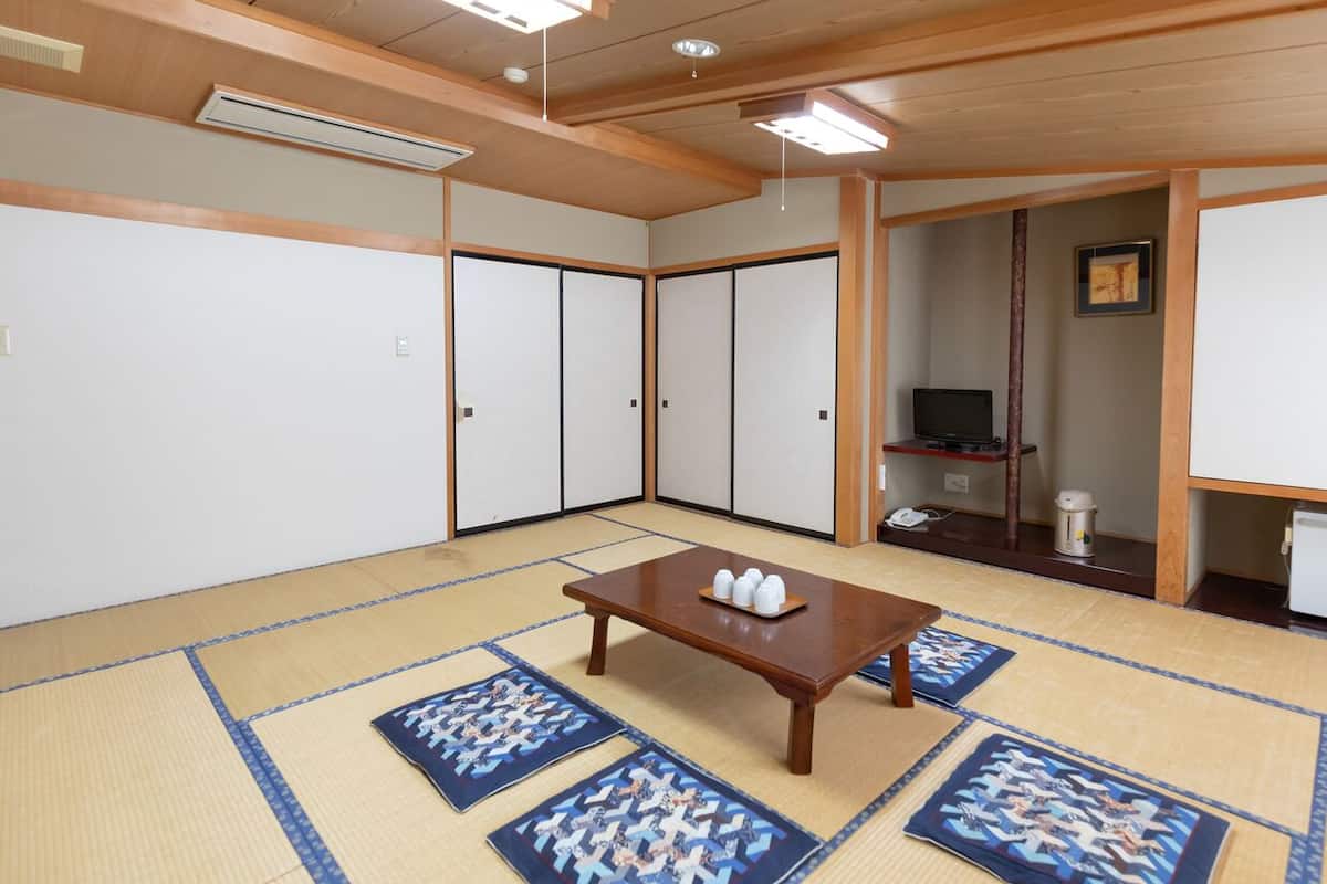 A traditional Japanese room with tatami flooring, a low wooden table, and sliding doors.