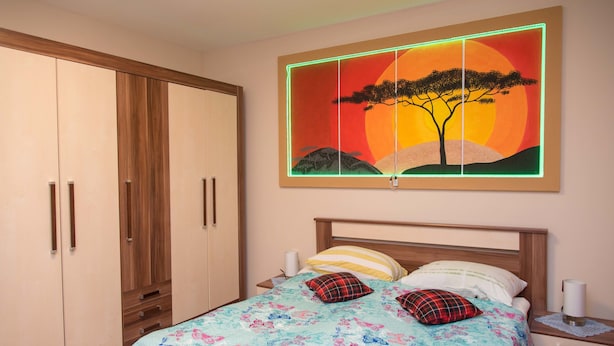 A bedroom with a bed, nightstands, a wardrobe, and a wall-mounted painting. - Rooms Vlado (Daruvar)