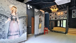 Una habitación con un mural grande en la pared, un banco y varias fotografías enmarcadas.