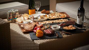 Una mesa de comedor dispuesta con diversos alimentos, bebidas y utensilios.