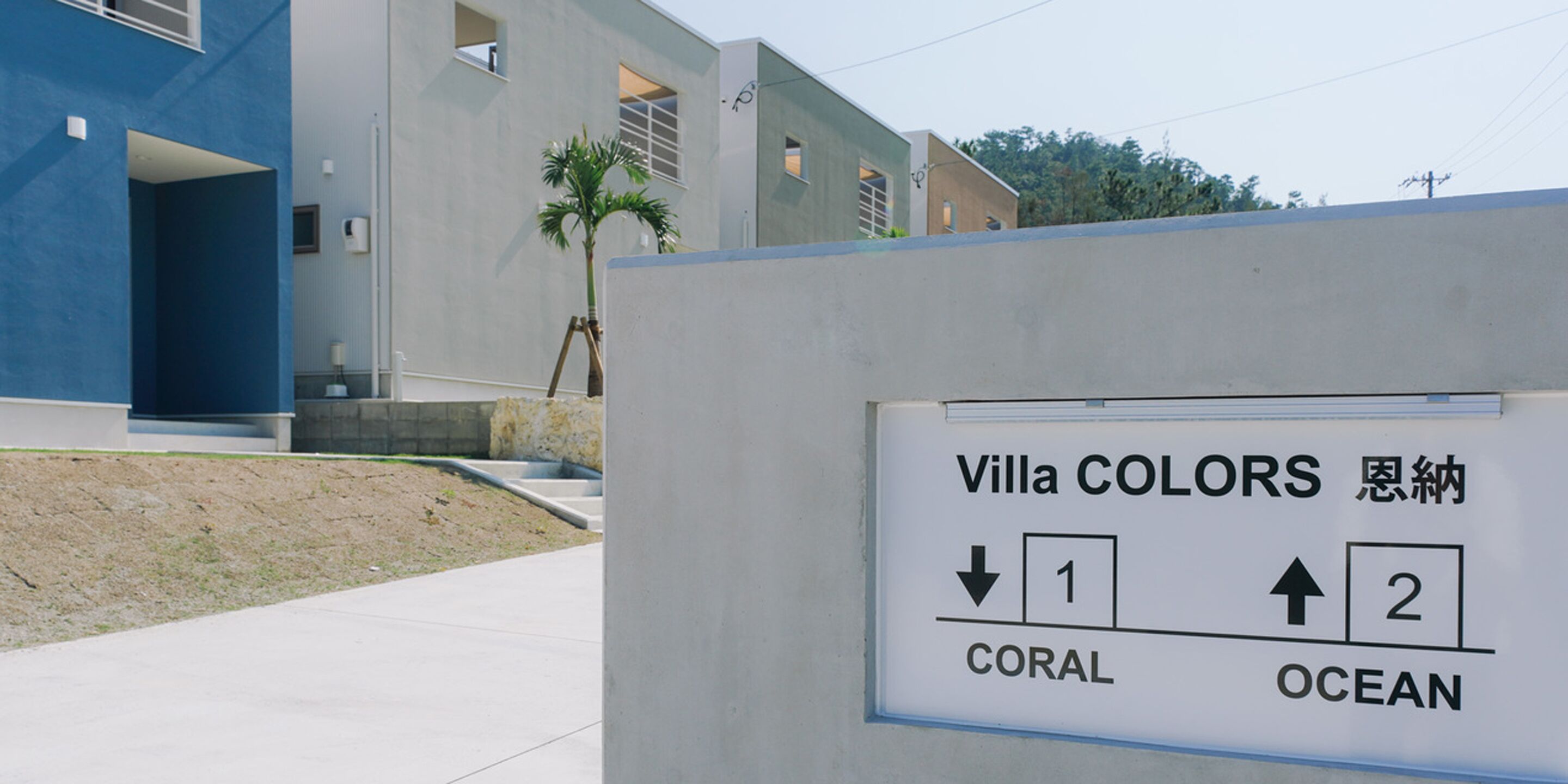 A sign indicating Villa COLORS with directional arrows pointing to 'CORAL' and 'OCEAN' areas.