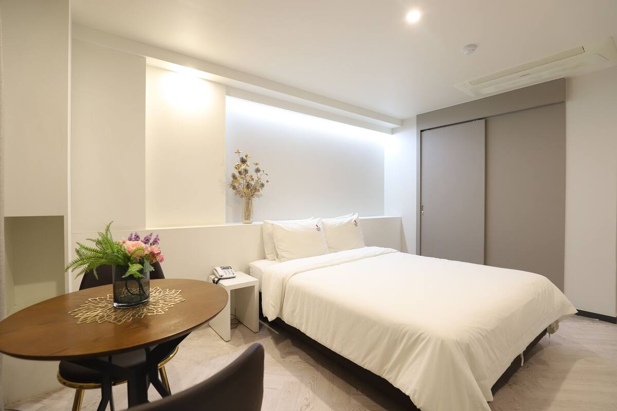 Premium bedding, desk, laptop workspace, blackout drapes