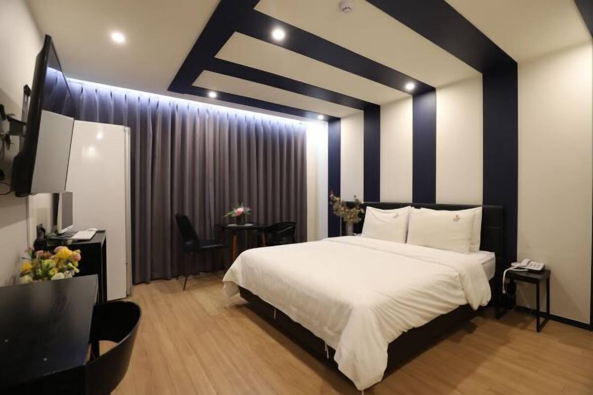 Premium bedding, desk, laptop workspace, blackout drapes