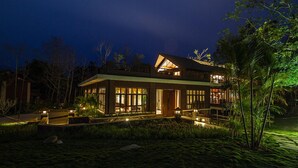 A modern house with large windows and a well-lit exterior at night.
