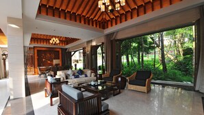 A spacious living area with a large window offering a view of a lush garden.