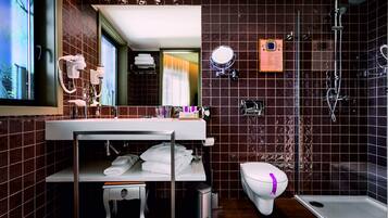 A modern bathroom with a vanity, a toilet, and a shower area.