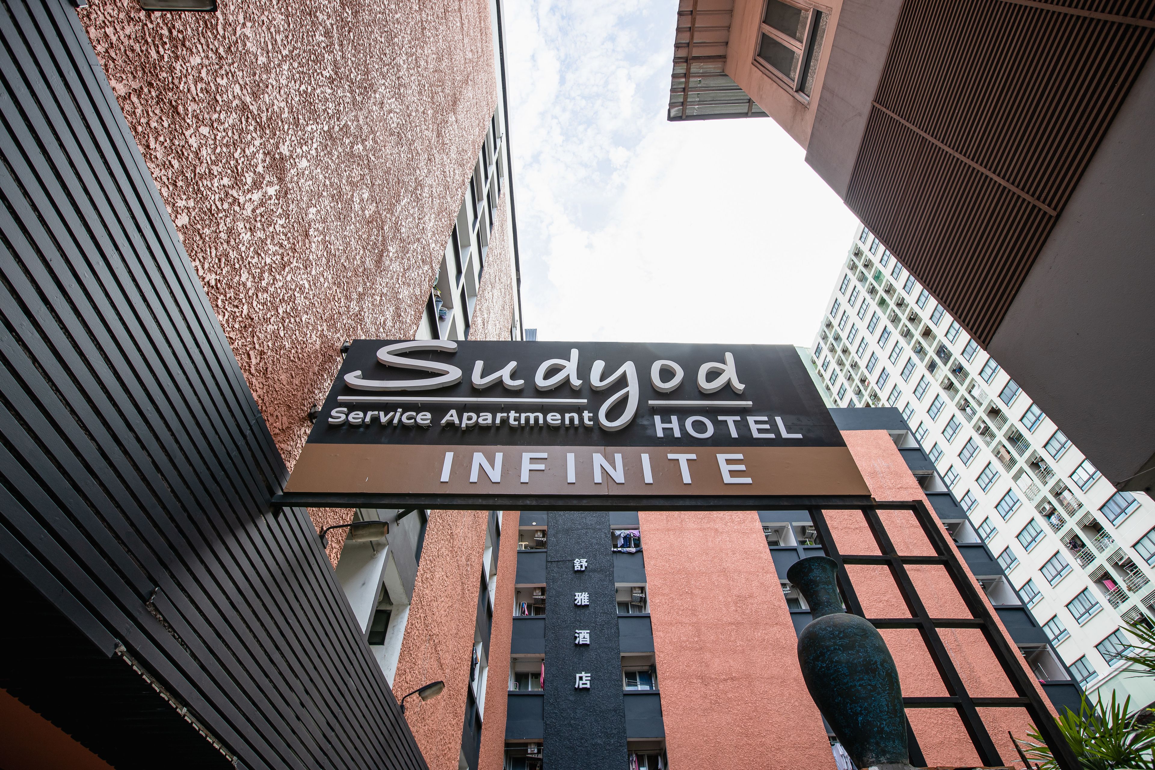 Une enseigne d’hôtel portant le nom « Sudoyo Service Apartment Hotel Infinite ».
