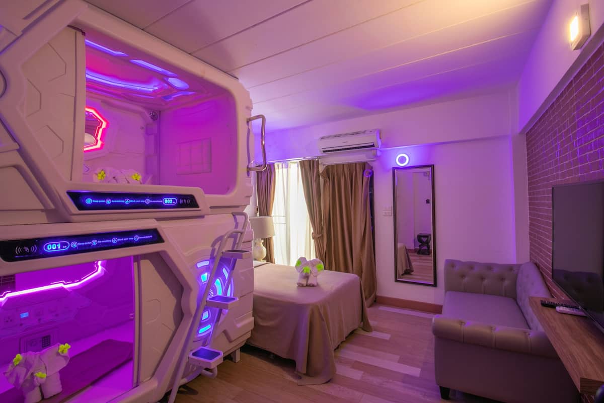 Une chambre moderne équipée d’un lit, d’une petite table, d’un canapé et d’un téléviseur.