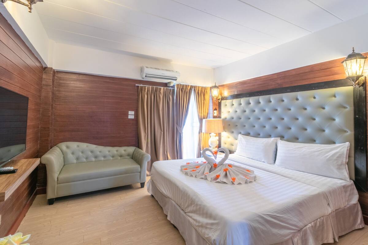 Une chambre d’hôtel équipée d’un lit, d’un canapé, d’une télévision et d’un appareil de climatisation.