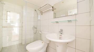 A bathroom with a toilet, sink, glass shower enclosure, and a towel rack.