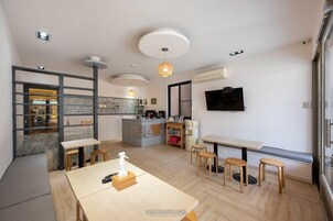 Un interior moderno con cocina, comedor y televisor montado en la pared.