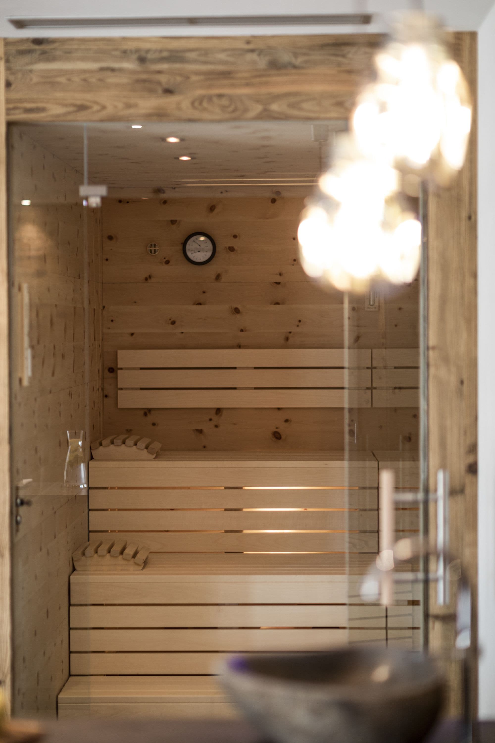 Un interior de madera con un banco, un reloj y una puerta de cristal.