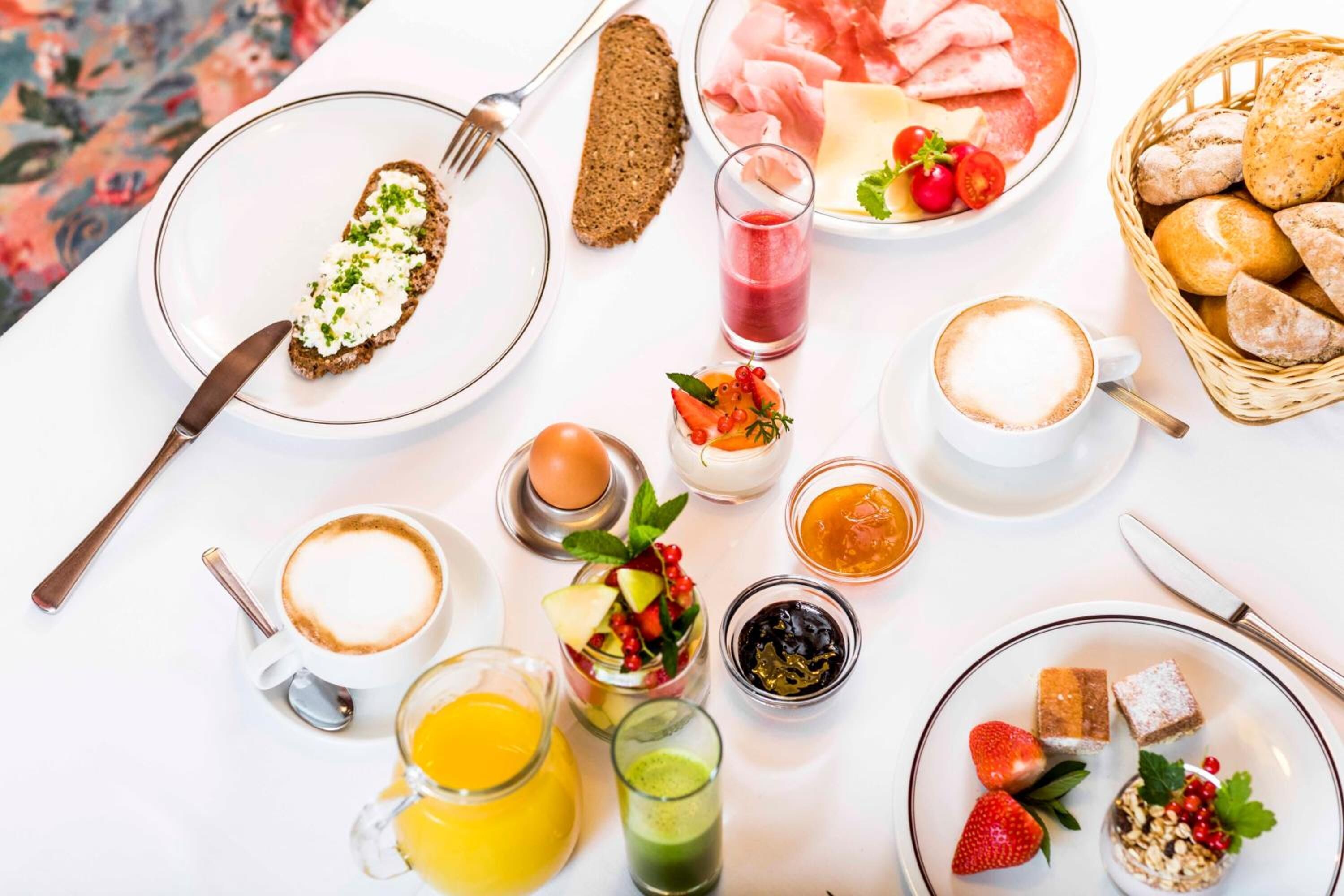 Un desayuno con diversas comidas y bebidas sobre una mesa.