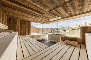 A wooden interior with benches and a view of mountains. - Hotel Rommisa (Perca)