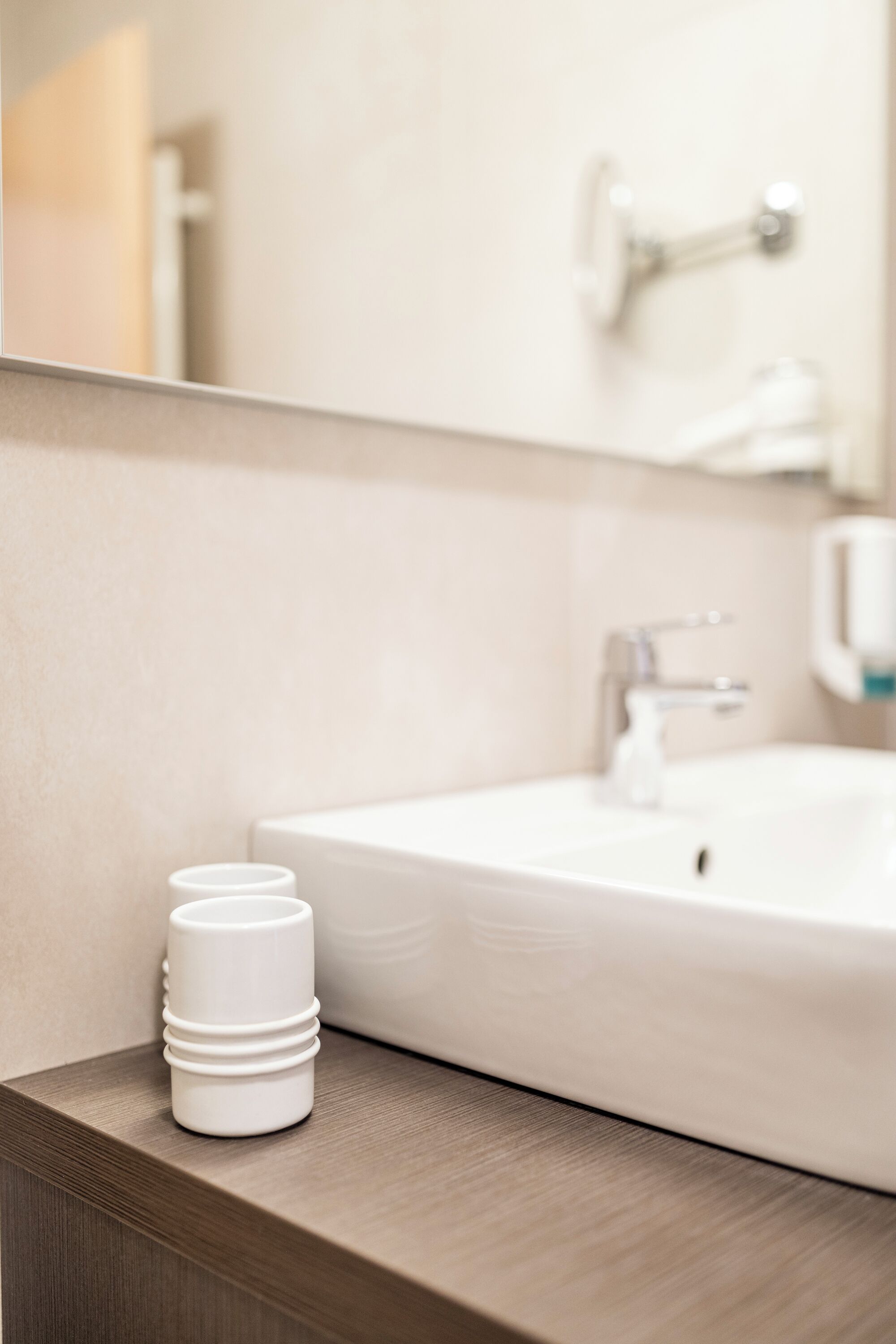 Un baño con lavamanos blanco, un espejo y encimera de madera.