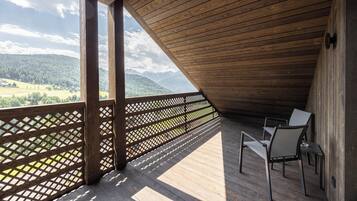 Una terraza de madera con vista a un paisaje montañoso.