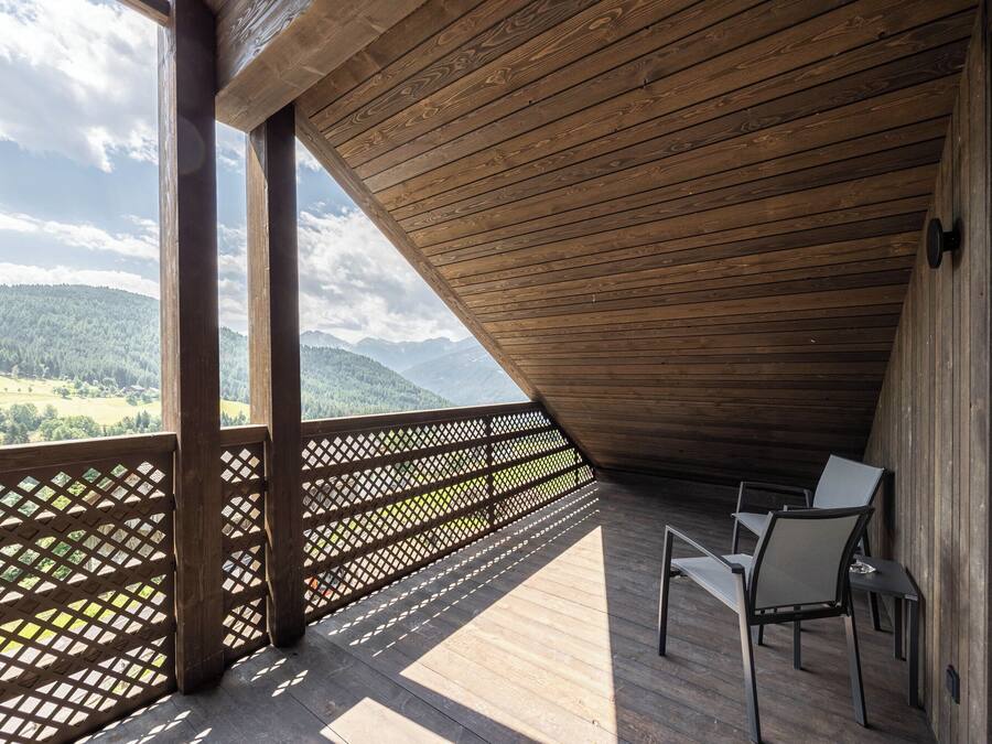 Une terrasse en bois offrant une vue sur un paysage montagneux.