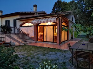 Une maison dotée d’un patio couvert, d’un escalier et d’un coin repas.