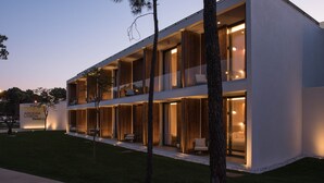 Un hotel moderno con techo plano, amplias ventanas y fachada bien iluminada.