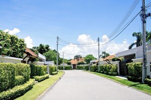 A residential street with houses on either side, a clear sky, and power lines overhead. - Busaba Villa 11 - 4 Bedroom - Pool (Hua Hin)