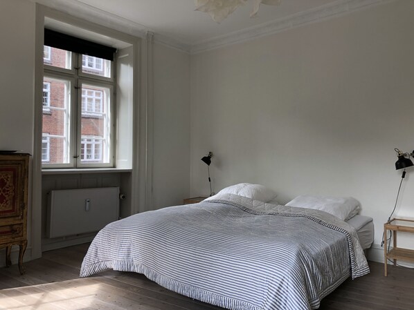 A bedroom with a bed, a radiator, a window, and a lamp. - Best Stay Copenhagen - Christianshavn (Copenhagen)