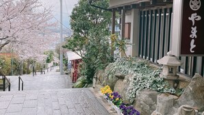 Un bâtiment traditionnel japonais avec un chemin de pierre menant à une porte.