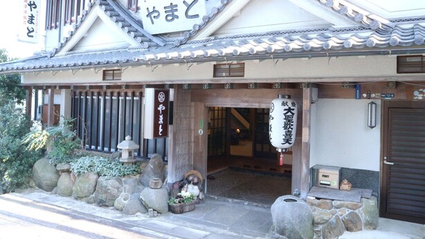Un bâtiment traditionnel japonais avec une enseigne indiquant « Yamato ».