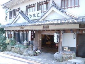 Un edificio tradicional japonés con un letrero que dice 'やまと'.