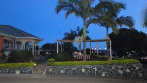 A stone wall, a gazebo, and a palm tree.