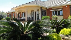 A two-story house with a covered porch, brick exterior, and a tiled roof.