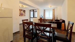 A compact living space with a dining area, a sofa, and a kitchen. - Apartment Sofia (Sinaia)
