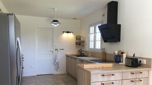 Une cuisine moderne équipée d’un réfrigérateur, de meubles de rangement en bois, d’un évier et d’un grille-pain.