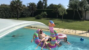 Une piscine à bord incurvé et à l’eau d’un bleu cristallin.
