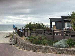 A coastal walkway with a wooden fence, a stone wall, and a view of the sea. - Blue Sheep. . (Barneville-Carteret)