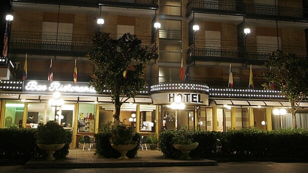 Un hôtel avec une enseigne bien visible, de nombreux étages et une entrée bien éclairée.