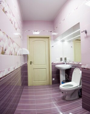Een douche, handdoeken, zeep, toiletpapier