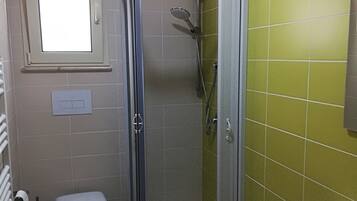 Un bagno con doccia, WC e lavandino.