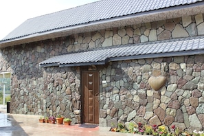 A stone building with a brown door and a heart-shaped stone on the wall. - Guba Panoramic Villa (Quba)