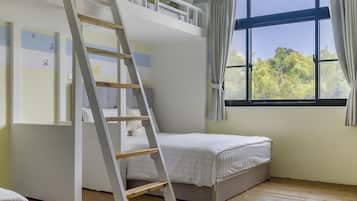 Habitación con literas, una escalera, ventana con cortinas y un diseño de mariposa en la pared.