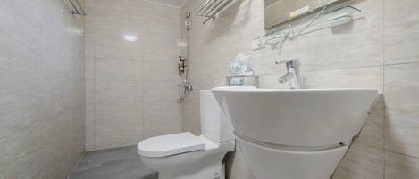 A modern bathroom with a toilet, bidet, and sink.