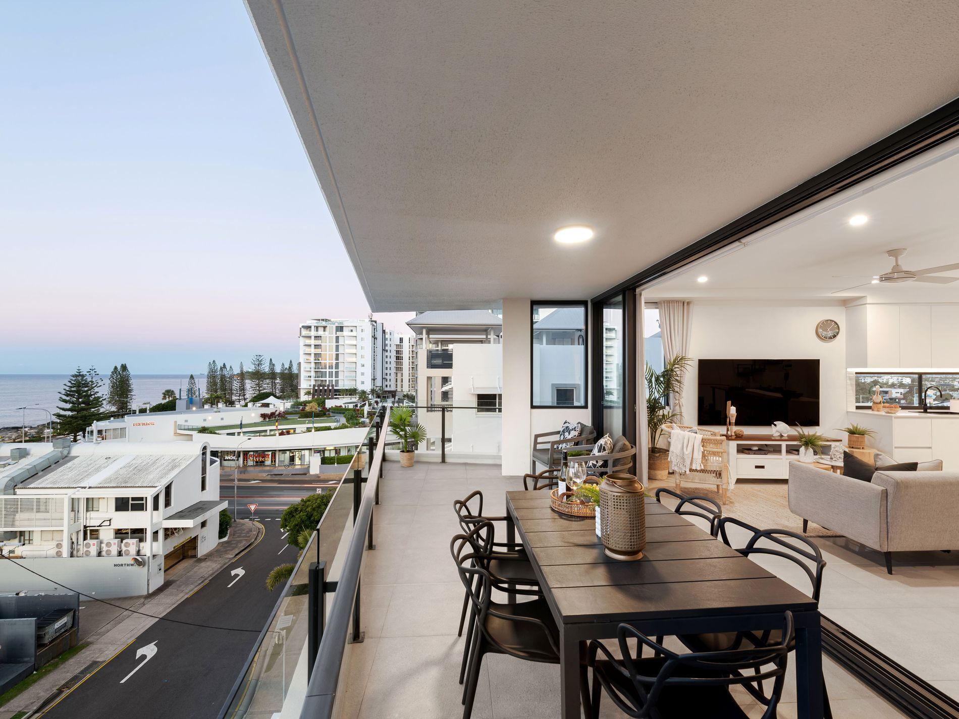 Un apartamento moderno con balcón que ofrece vistas a la ciudad y al mar.