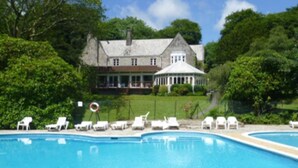 A large house with a swimming pool and lounge chairs. - Welcome to Poldark Country - A Cornish Idyll! (Camelford)