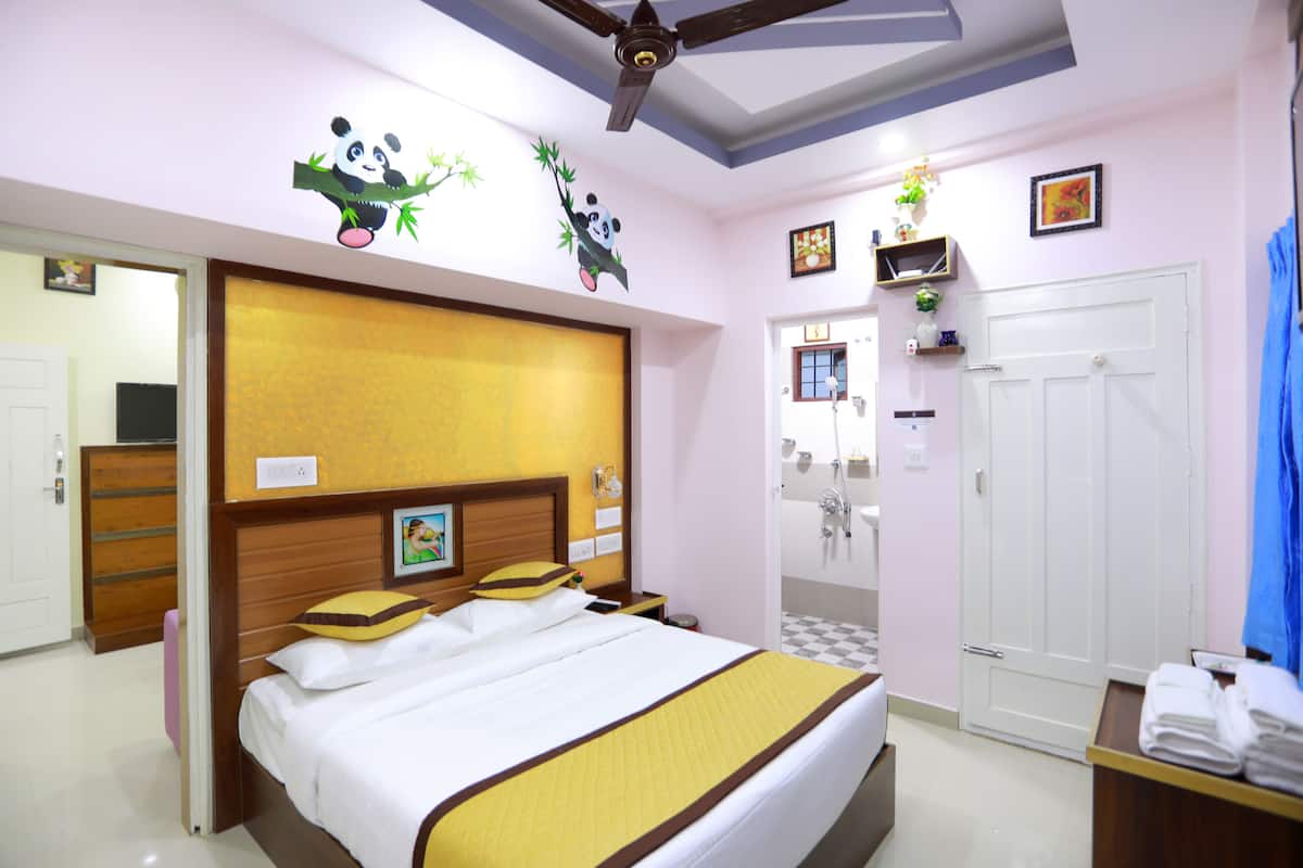 A hotel room with a bed, a shower, a wardrobe, and a ceiling fan.