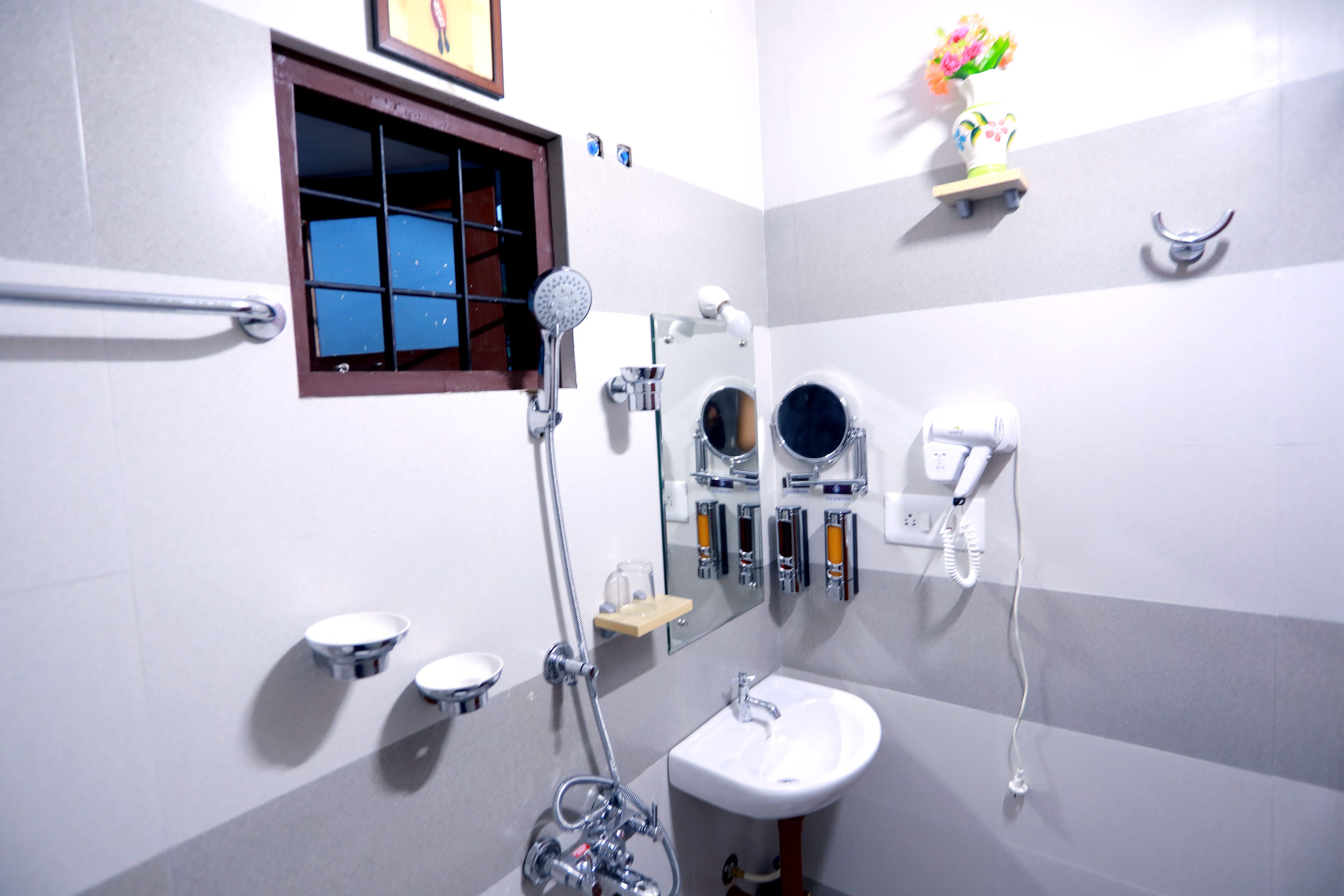 Ein Badezimmer mit Dusche, Waschbecken und zwei Spiegeln.