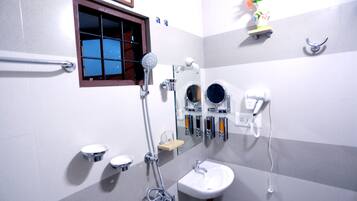 Ein Badezimmer mit Dusche, Waschbecken und zwei Spiegeln.