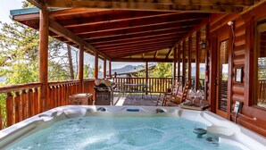 Ein Whirlpool auf einer Holzterrasse mit Bergblick.
