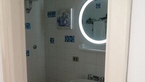 A bathroom with a toilet, sink, and mirror. - House near the sea and near the NEGOMBO spa complex (Lacco Ameno)