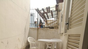 A small outdoor patio with a tiled floor, a white table, and two white plastic chairs. - House near the sea and near the NEGOMBO spa complex (Lacco Ameno)