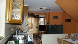 Una cocina con armarios de madera, una mesa de comedor y un televisor.