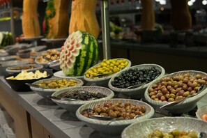 A buffet with various food items including olives, fruits, and a watermelon centerpiece. - Signature Hotels & Spa (Ürgüp)